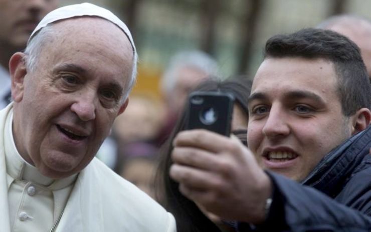 POPE SELFIE. Pope Francis poses for a selfie with a faithful as he arrives at the Parish of San Giuseppe all'Aurelio to lead a mass, in Rome, Italy, 14 December 2014. EPA/CLAUDIO PERI