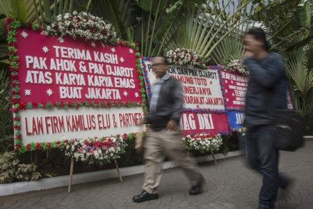 Warga melintas di antara karangan bunga berisi ucapan terima kasih kepada Basuki Tjahaja Purnama dan Djarot Saiful Hidayat di kawasan Balai Kota DKI Jakarta, Jakarta, Senin (9/10). Foto oleh Aprillio Akbar/ANTARA 