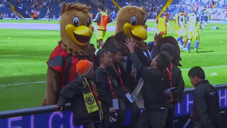 HAVING FUN. The kids interacting with mascots during a football match