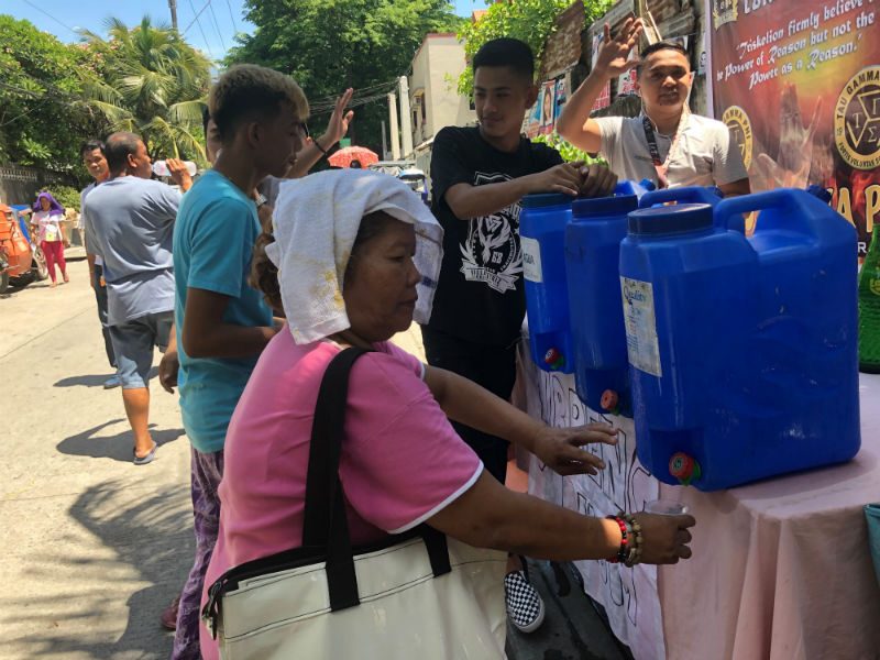 FREE WATER. Residents cool off with free water offered by volunteers on the way to polling centers. Photo by Sofia Tomacruz/Rappler 