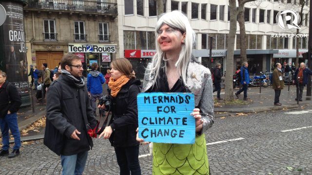 SAVE THE OCEAN. A live mermaid makes it through the street of Paris to advocate for climate justice. 