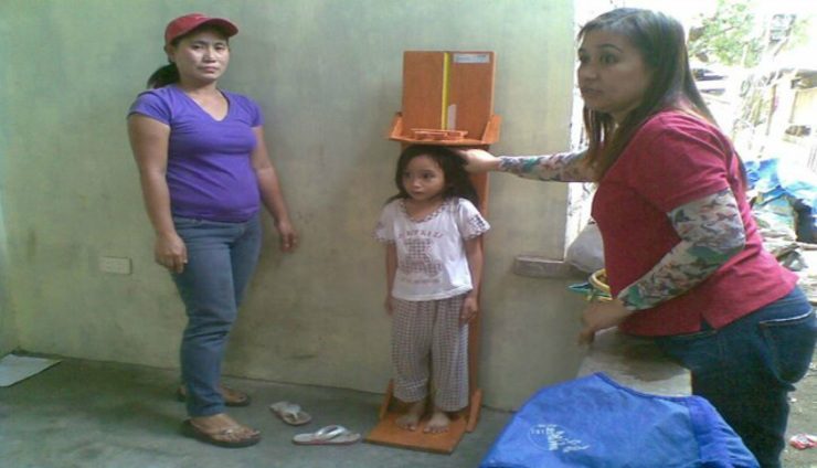 MEASURE. A child's child is measured using a height board. Photo from Barangay Nutrition Scholars Federation
