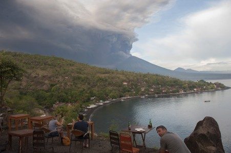 Sejumlah wisatawan menyaksikan letusan Gunung Agung dari Pantai Jemeluk, Karangasem, Bali, Minggu (26/11). FOTO oleh ANTARA/Nyoman Budhiana 