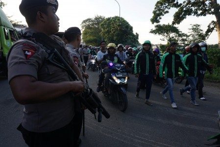 Polisi menghalau pengemudi ojek "online" seusai saat bentrok dengan pengemudi angkutan umum di kawasan Sangiang, Tangerang, Banten, Rabu (8/3). Foto oleh Lucky R/ANTARA 