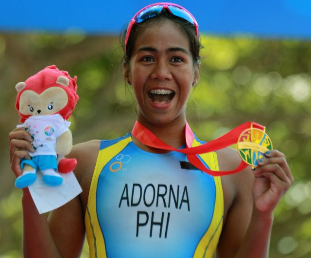 GOLDEN GIRL. An ecstastic Adorna shows of her women's triathlon gold – the country’s first at the 28th Southeast Asian Games. Photo by Reuters  