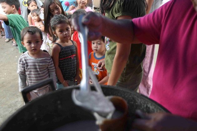 SATING HUNGER. Children line up at a feeding program for informal settlers in Quezon City. File photo by Rolex dela Pena/ EPA