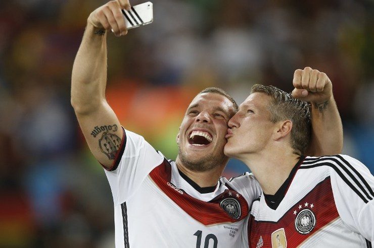 Lukas Podolski and Bastian Schweinsteiger take a 'selfie' after their victory in extra-time in the World Cup final. Photo by Adrian Dennis/AFP