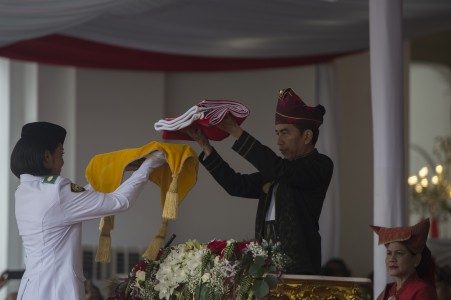 Presiden Joko Widodo (kanan) menyerahkan duplikat Sang Saka Merah Putih kepada Pembawa Bendera Merah Putih Fariza Putri Salsabila (kiri) di Istana Merdeka, Jakarta, Kamis (17/8). FOTO oleh Rosa Panggabean/ANTARA 