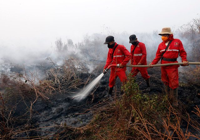 PEMADAM. Petugas pemadam kebakaran berupaya memadamkan api di lahan gambut di Reding, Ogan Komering Ilir, Sumatera Selatan, 14 September. Foto oleh Adi Weda/EPA 