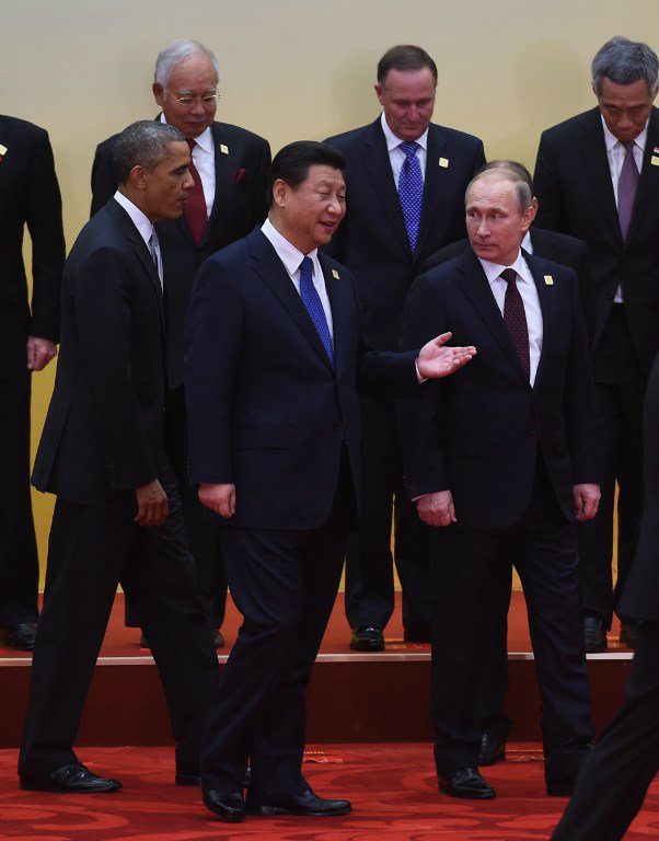 PRE-PLANNED. Chinese President Xi Jinping gestures as US President Barack Obama and Russian President Vladimir Putin (R) look on at the end of a group photo of leaders of Asia-Pacific Economic Cooperation (APEC) economies at Yanqi Lake, north of Beijing on November 11, 2014. Details in APEC like who sits and stands where are prepared well ahead of time. File photo by Greg Baker/AFP   