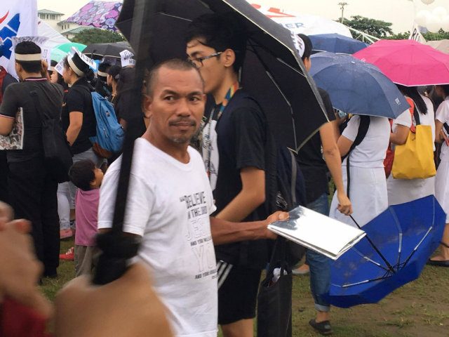 SLOW BUSINESS. Baylon sells foil covers to protesters who want to sit on the muddy grounds at the Quirino grandstand. Photo by Khristine Montenegro/Rappler  