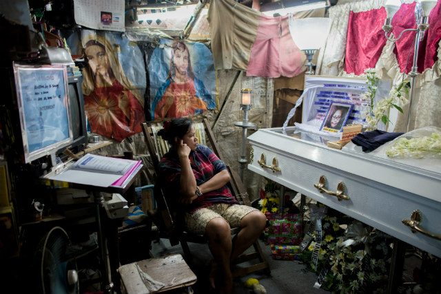 TOO SOON. Kimberly Sailog watches over the casket of her 12-year old daughter Kristine Joy in their shanty home on Christmas Eve, December 24, 2016. Photo by Eloisa Lopez 