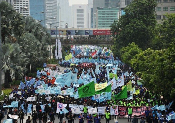 Thousands of Indonesian workers rally to demand higher wages and scrap the labor outsourcing policy as they march to the presidential palace in Jakarta on October 17, 2013. Photo by Bay Ismoyo/AFP