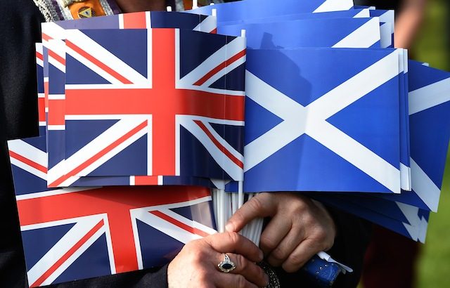 A Unionist holds the Union jack (L) and the Saltire flag during a march of the Orange Order in a show of solidarity for the Union of Britain in Edinburgh, Scotland, 13 September 2014. Andy Rain/EPA