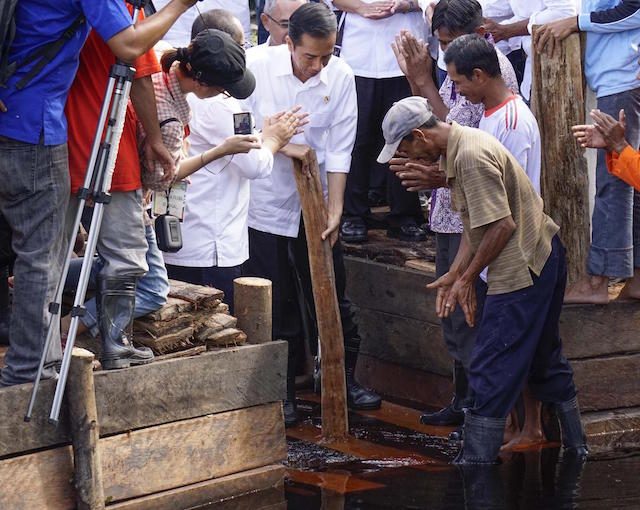 Presiden Jokowi memasang sekat kanal di sebuah sungai di Riau, pada 27 November 2014. Foto oleh Greenpeace Indonesia 