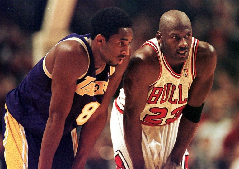 Kobe Bryant and Michael Jordan share a word during a game in December 1997. Bryant would draw comparisons to Jordan throughout his career. Photo by Vincent Laforet/AFP 