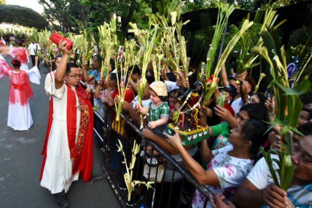 BLESSING OF PALMS. A priest blesses palm fronds outside Baclaran Church in Parañaque City on Palm Sunday, March 25, 2018. Photo by Angie de Silva/Rappler   