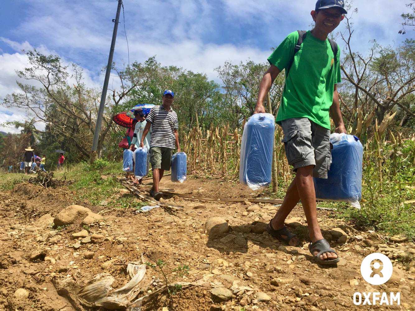 Locals of Rizal town led by its officials helped in carrying water supplies for two remote communities. Photo by April Bulanadi/Oxfam 