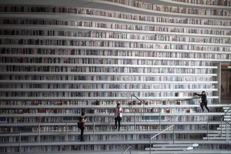 FUTURISTIC. A picture taken on November 14, 2017, shows people visiting the Tianjin Binhai Library that has wowed book lovers around the world with its white undulating shelves rising from floor to ceiling. Photo by Fred Dufour/AFP  