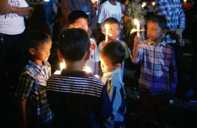 LILIN HARAPAN. Anak-anak korban gusuran menyalakan lilin. Foto oleh @cahayagusuran 