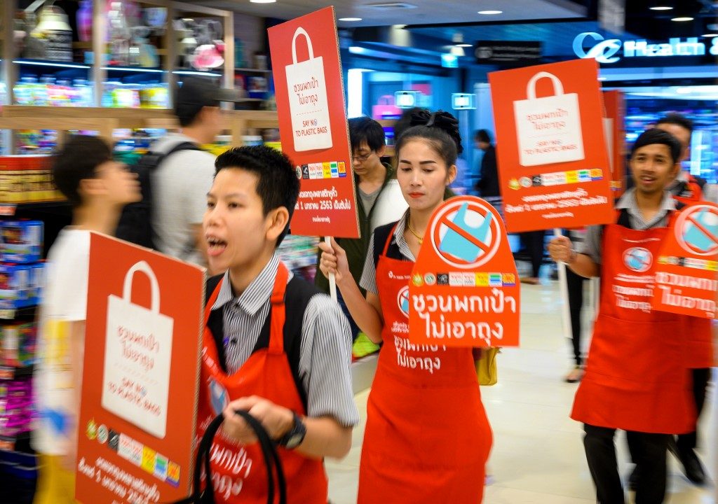 NO TO PLASTIC. Employees carry banners informing customers about the ban on free single-use plastic bags at a shopping mall in downtown Bangkok on January 2, 2020. Photo by Mladen Antonov/AFP  