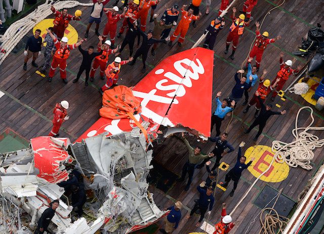 DEBRIS. Rescuers and divers gather near the tail of AirAsia QZ8501 plane on the deck of the Indonesian Rescue ship Crest Onyx after lifted from the sea floor off Pangkalan Bun, Central Kalimantan, on January 10, 2015.  Photo from EPA 