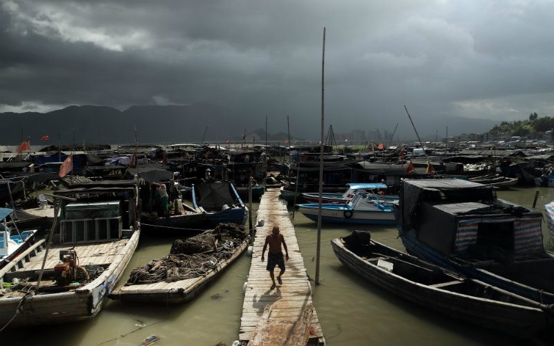 A fisherman walks on the pier in a safe harbor ahead of the arrival of supertyphoon Soudelor in Ningde in southeast China's Fujian province 07 August 2015. Photo by Liu Tao/EPA 