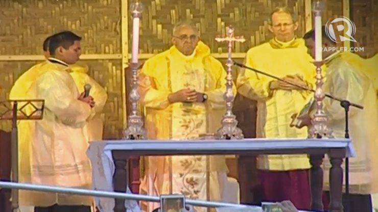 Pope in raincoat says mass in Tacloban