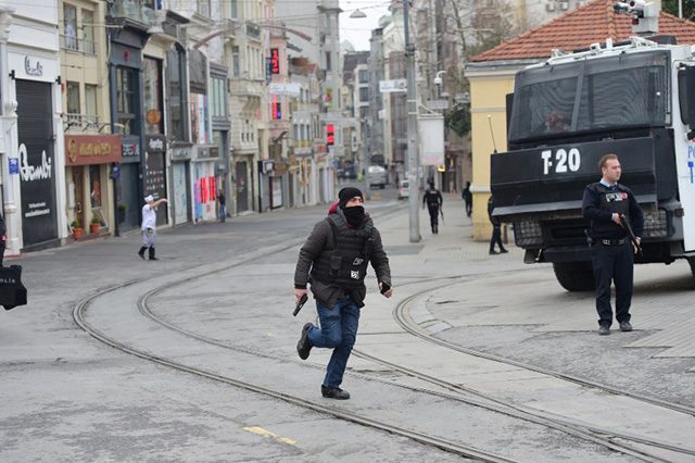 REACTING. A Turkish policeman runs after an explosion on the pedestrian Istiklal avenue in Istanbul on March 19, 2016. Four people, including the bomber, were killed and twenty others injured in a suicide attack on a major shopping street in Istanbul on Saturday, the city governor reported. Bulent KILIC / AFP 