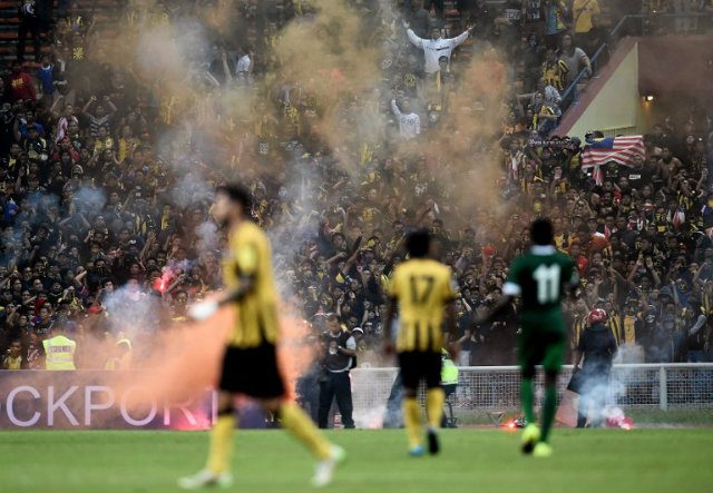 SANCTIONED. Malaysian football fans throw flares onto the pitch during the 2018 FIFA World Cup qualifying football match between Malaysia and Saudi Arabia. File photo by Manan Vatsyayana/AFP  