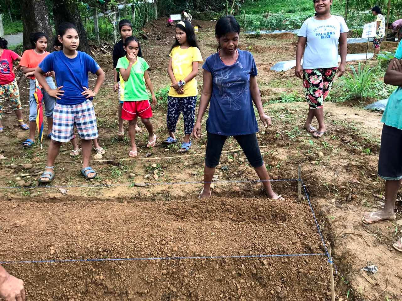 READY. A group of Mangyan mothers gather around to prepare the mound of land for planting. Photo from ZEP 2030 
