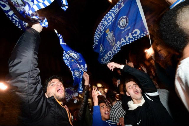 Leicester City fans wave flags as they celebrate their team becoming the English Premier League football champions in central Leicester, eastern England, on May 2, 2016, after Chelsea held Tottenham Hotspur to a 2-2 draw in the English Premier League match. File Photo by LEON NEAL / AFP  