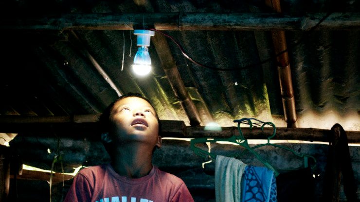 FINALLY, POWER. A boy looks up at a lightbulb powered by a solar panel installed in his home in Tanauan, Leyte. Photo by Nim Gonzales