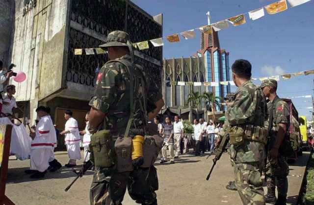 THREATS. Army soldiers guard a Christian procession marking the anniversary of the Jolo's Mount Carmel Cathedral in the aftermath of attacks in 2000. Photo by Romeo Gacad/AFP   