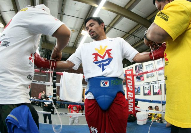 Manny Pacquiao gets gloved up for his training session. Photo by Chris Farina - Top Rank 