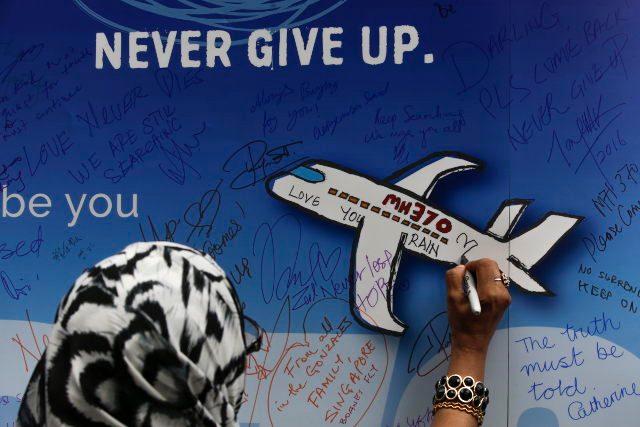 MH370. Sebuah foto yang diambil pada tanggal 6 Maret 2016 menunjukan seorang perempuan tengah menulis bagi penumpang maskapai Malaysia Airlines MH370 yang hilang pada 8 Maret 2014. Foto oleh Fazry Ismail/EPA 