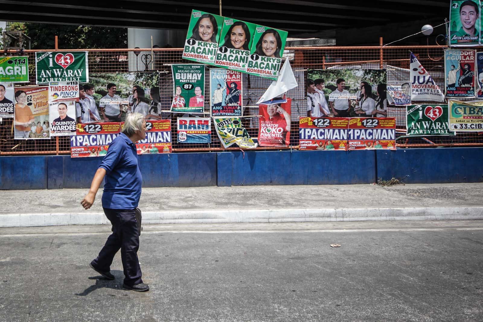 A man walks past through the political poster along Legarda extension in Manila on March 30, 2019. Photo by Lito Borras/Rappler 