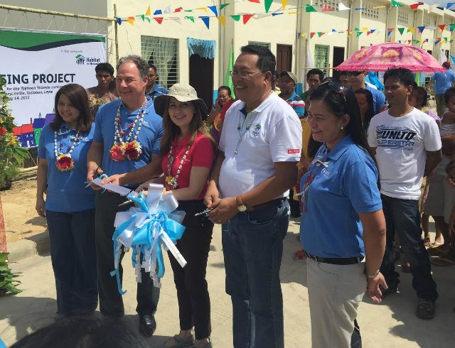 HOUSES DISTRIBUTED. Tacloban First Councilor Cristina G. Romualdez, along with AES’ Scott Kicker, and Habitat for Humanity CEO Charlie Ayco, leads the ribbon-cutting ceremony and distribution of 25 typhoon-proof houses to 25 families of Yolanda survivors on July 14. Photo by Jed Cortes/Rappler  