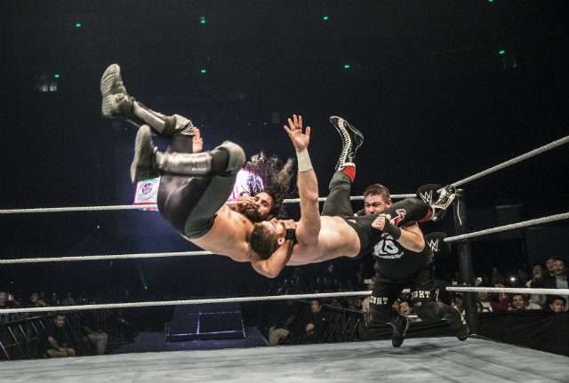 Kevin Owens powerbombs Seth Rollins and Sami Zayn after Zayn attempted a superplex at WWE Manila. Photo from WWE 