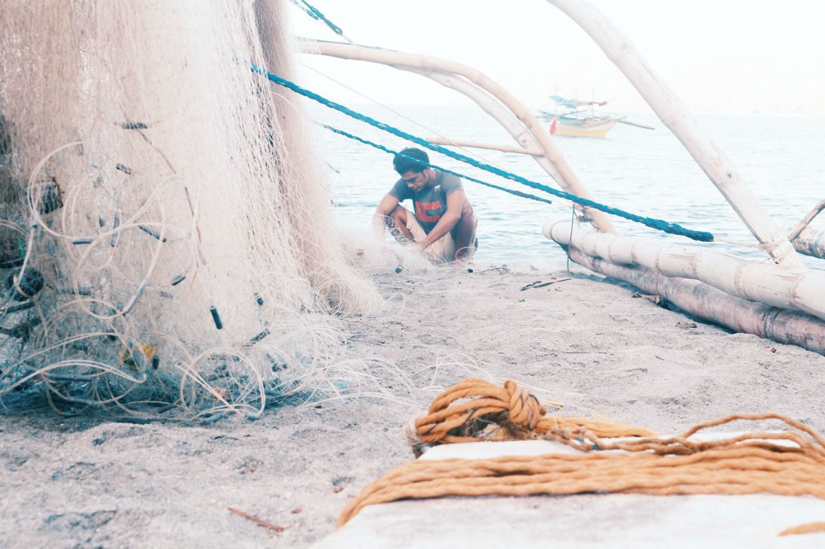 EARLY DUTY. A local prepares his fishing net for the day's catch in Zambales. 
