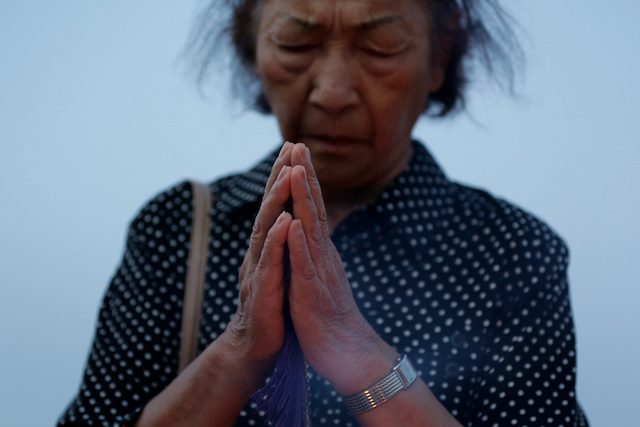 Seorang perempuan berdoa khusyuk untuk para korban jatuhnya bom atom Hiroshima 70 tahun yang lalu