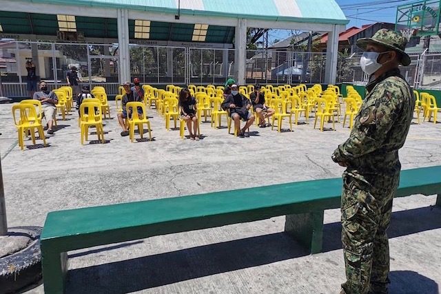 LOOK: In Parañaque, curfew violators sit under the sun as punishment