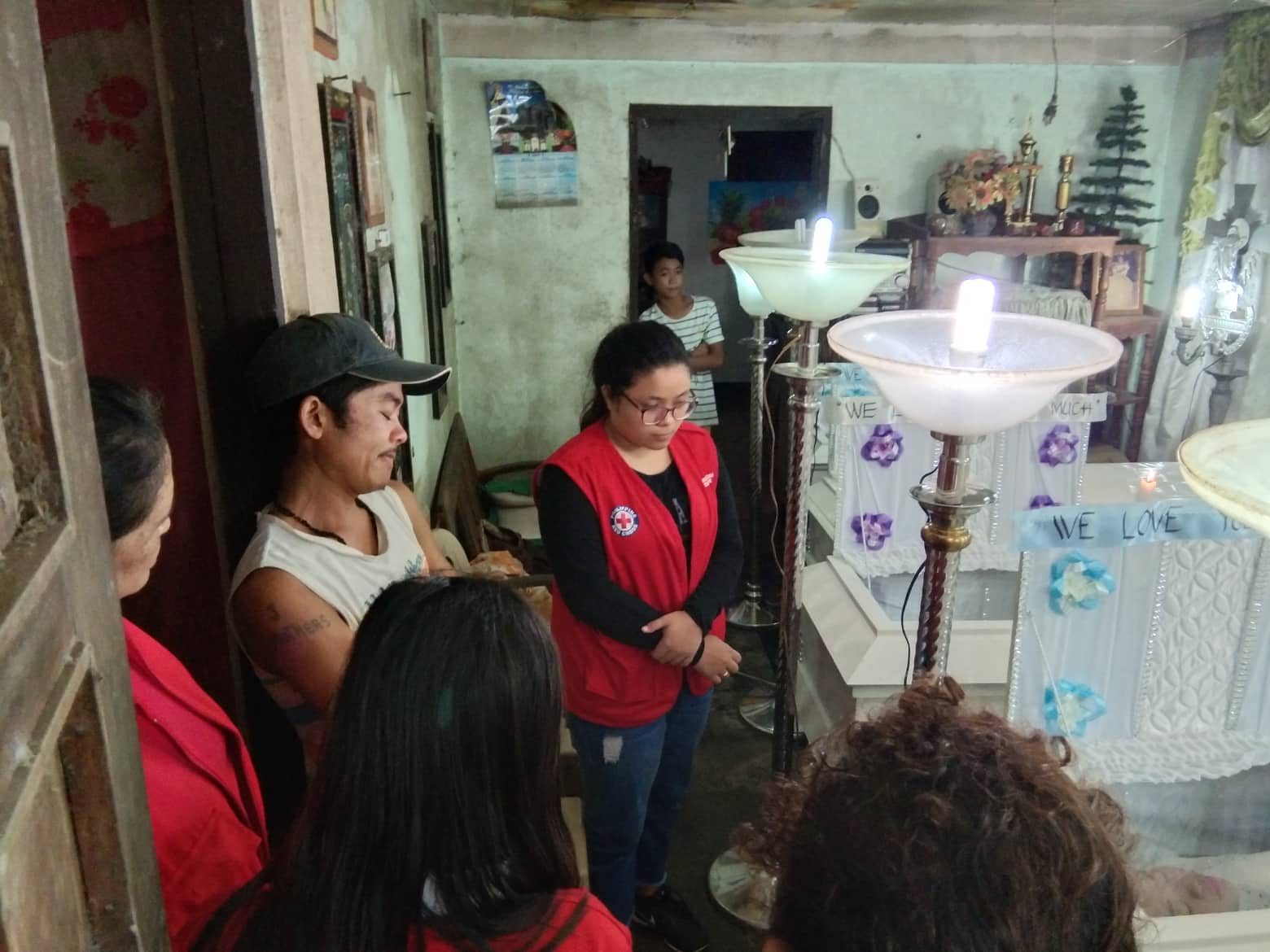 ASSISTANCE. Members of the Philippine Red Cross - Camarines Sur provide a psychosocial service briefing to Benjie de Lima of San Vicente in Baao town, who lost his wife and 4 children on Sunday. Photo courtesy of Philippine Red Cross-CamSur  