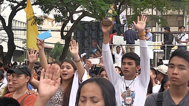 PHONES AND STATUES: Filipino Catholics attend the first mass of Pope Francis at the Manila Cathedral Rappler photo