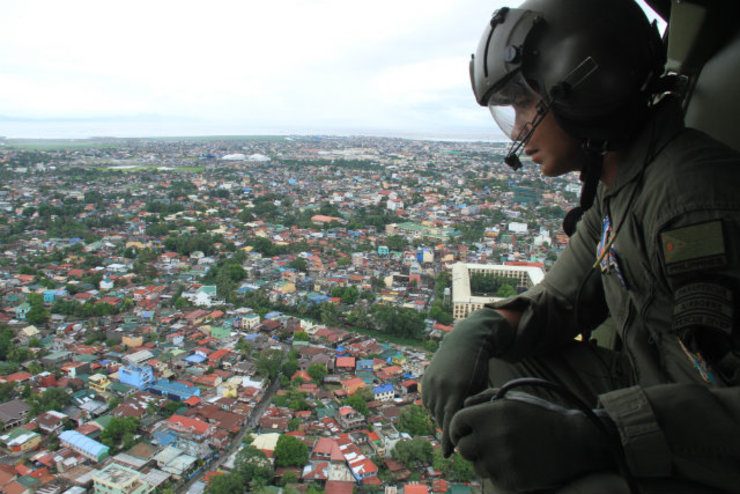 SURVEY. A soldier looks on during the aerial survey of areas affected by Typhoon Glenda. Photo courtesy of the Philippine Air Force