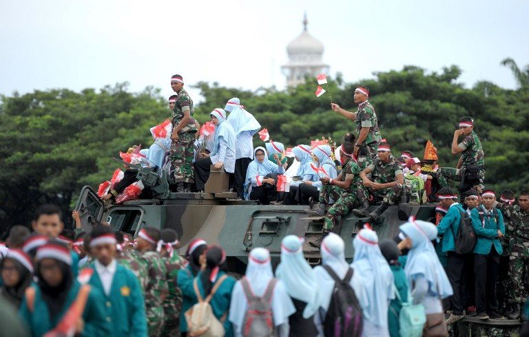 Masyarakat Indonesia melakukan unjuk rasa untuk perdamaian menjelang protes massal umat Islam