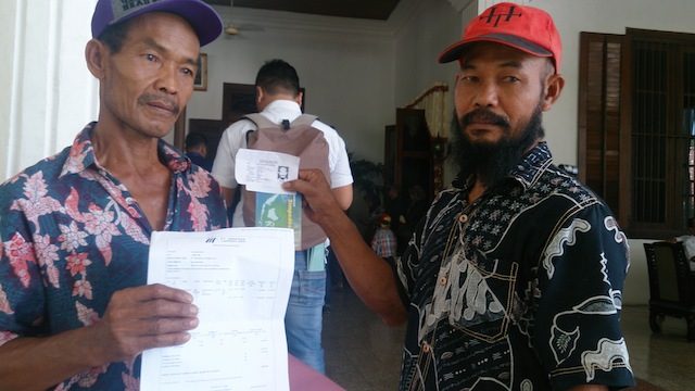 Sudayat (kiri) dan Abdul Rosyid, warga korban lumpur Lapindo, membawa persyaratan berkas untuk validasi di Pendopo Pemkab Sidoarjo. Foto oleh Agung Putu Iskandar/Rappler  