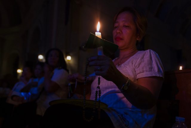 CANDLE-LIT MASS. Mass-goers hold candles inside the Malate Church as they observe Earth Hour. Photo by Maria Tan/Rappler 