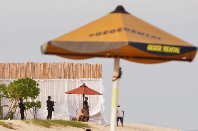 LIBURAN. Petugas melakukan pengamanan wilayah pantai yang ditutup dengan pagar bambu di kompleks Hotel St Regis, Nusa Dua, Bali, Senin, 6 Maret. Foto oleh Fikri Yusuf/ANTARA 