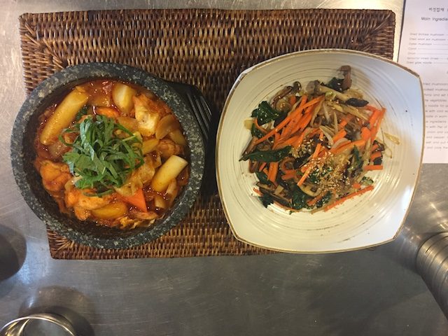 SPICE IS NICE. On the left, dak galbi or spicy chicken stew, and on the right, japchae or stir-fried potato noodles.  